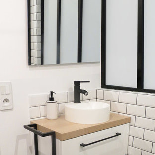 Cette photo montre une douche en alcôve principale tendance de taille moyenne avec un placard à porte plane, des portes de placard blanches, un carrelage blanc, des carreaux de céramique, un mur blanc, un sol en carreaux de ciment, un plan de toilette en bois, un plan de toilette beige, une vasque et un sol multicolore.