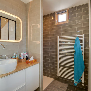 Exemple d'une très grand salle de bain scandinave avec un placard à porte plane, des portes de placard blanches, un espace douche bain, un carrelage beige, un mur beige, une vasque, un plan de toilette en bois, aucune cabine et un plan de toilette marron.