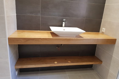 Inspiration for a medium sized traditional shower room bathroom in Reims with light wood cabinets, a built-in shower, a wall mounted toilet, grey tiles, ceramic tiles, beige walls, ceramic flooring, a built-in sink, wooden worktops and beige floors.