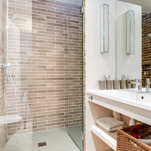 Aménagement d'une salle de bain contemporaine de taille moyenne avec un WC suspendu, un carrelage beige, un mur blanc, un sol en carrelage de céramique, un lavabo intégré et une cabine de douche à porte battante.