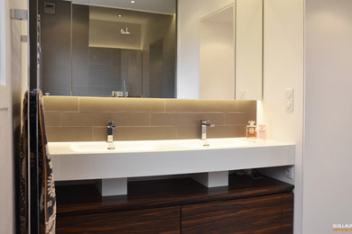 Cette image montre une salle de bain design avec une douche à l'italienne, un carrelage gris, un plan vasque et un plan de toilette en surface solide.