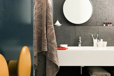 Idée de décoration pour une salle de bain design avec une douche à l'italienne, des dalles de pierre, un plan vasque et un plan de toilette en surface solide.