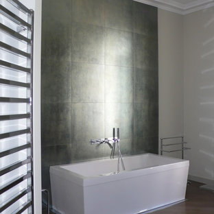 Inspiration pour une salle de bain principale minimaliste de taille moyenne avec un carrelage gris, un mur blanc, un sol en bois foncé et une baignoire indépendante.