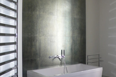 Diseño de cuarto de baño principal minimalista de tamaño medio con baldosas y/o azulejos grises, paredes blancas, suelo de madera oscura y bañera exenta