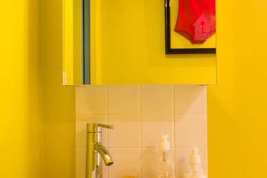 Cette photo montre une salle de bain tendance avec un carrelage blanc et un mur jaune.