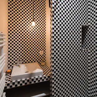 Aménagement d'une petit salle d'eau contemporaine avec une vasque, un placard sans porte, un mur blanc, carrelage en mosaïque, des portes de placard blanches et un carrelage noir et blanc.