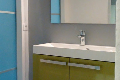 Modelo de cuarto de baño actual pequeño con puertas de armario verdes, ducha a ras de suelo, paredes grises, suelo de linóleo, aseo y ducha y lavabo suspendido