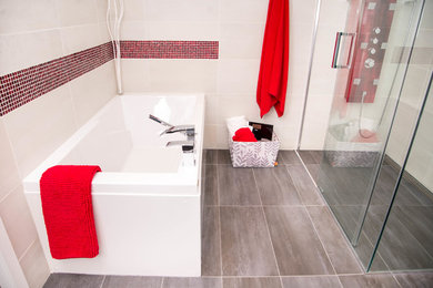 Exempel på ett mellanstort modernt en-suite badrum, med ett fristående handfat, bänkskiva i kvartsit, ett platsbyggt badkar, en kantlös dusch, beige kakel, porslinskakel och klinkergolv i porslin