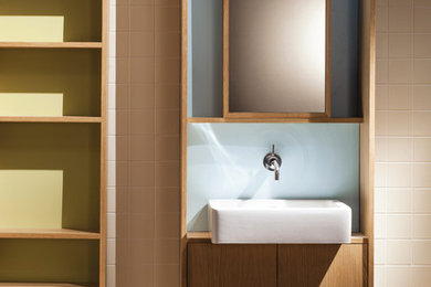 Cette photo montre une grande salle de bain principale tendance en bois clair avec un placard sans porte, un carrelage beige, un mur beige, parquet clair et un lavabo suspendu.