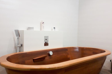 Aménagement d'une salle de bain principale contemporaine de taille moyenne avec une baignoire posée, un carrelage blanc, des carreaux de céramique, un mur blanc, un sol en carrelage de céramique, un lavabo suspendu, un sol marron, un plan de toilette blanc et meuble double vasque.