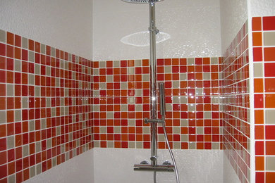 Diseño de cuarto de baño actual con baldosas y/o azulejos rojos y baldosas y/o azulejos de vidrio