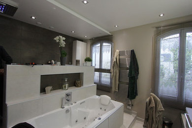 Cette image montre une salle de bain principale design de taille moyenne avec des portes de placard blanches, un bain bouillonnant, un sol en carrelage de céramique, une vasque et un sol blanc.