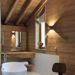 Idée de décoration pour une salle de bain chalet de taille moyenne avec un carrelage blanc, des carreaux de céramique, un sol en carrelage de céramique, un lavabo intégré, un plan de toilette en surface solide, un sol blanc, un plan de toilette blanc, un placard à porte plane, des portes de placard en bois sombre, une baignoire indépendante et un mur marron.