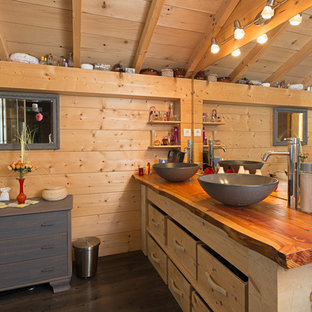 Exemple d'une salle de bain principale montagne de taille moyenne avec un placard en trompe-l'oeil, des portes de placard en bois clair, un mur marron, un sol en bois foncé, une vasque et un plan de toilette en bois.