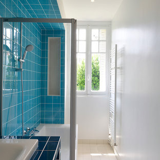 Inspiration pour une salle de bain principale design avec une baignoire posée, un combiné douche/baignoire, un carrelage bleu, un mur blanc, un lavabo encastré et un plan de toilette en carrelage.