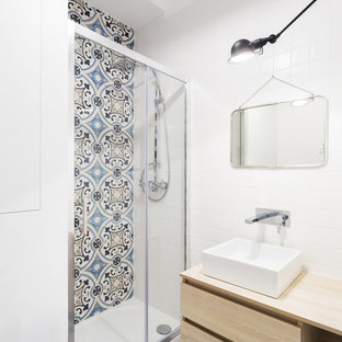 Exemple d'une petit salle d'eau scandinave avec un placard à porte plane, des portes de placard en bois clair, un carrelage bleu, des carreaux de céramique, un mur blanc, un plan vasque et un sol bleu.