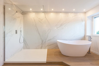 Large modern shower room bathroom in Strasbourg with white cabinets, a freestanding bath, a built-in shower, white tiles, marble tiles, white walls, a console sink, marble worktops, beige floors and an open shower.