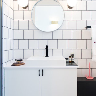 Aménagement d'une petit salle de bain contemporaine avec un lavabo posé, un carrelage blanc, un mur blanc et des portes de placard blanches.