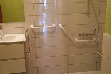 Cette image montre une salle de bain principale méditerranéenne de taille moyenne avec des carreaux de céramique, une douche ouverte, un mur gris, un sol en carrelage de céramique, un lavabo intégré, un sol marron et une cabine de douche à porte coulissante.