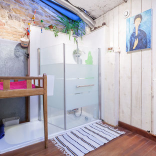 Cette image montre une salle d'eau bohème de taille moyenne avec une baignoire encastrée, un combiné douche/baignoire, un mur blanc et un sol en bois brun.