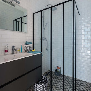 Réalisation d'une salle d'eau urbaine de taille moyenne avec des portes de placard noires, une douche à l'italienne, un mur blanc, un lavabo intégré, un carrelage métro et un carrelage noir et blanc.