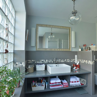 Inspiration pour une salle de bain traditionnelle avec un placard sans porte, des portes de placard grises, un WC suspendu, un carrelage gris, des carreaux de céramique, un mur bleu, un sol en carrelage de céramique et un lavabo posé.