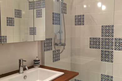 Idées déco pour une petite salle d'eau méditerranéenne avec un lavabo encastré, un plan de toilette en bois, une douche ouverte, un carrelage bleu, des carreaux de béton, un mur gris et un sol en bois brun.