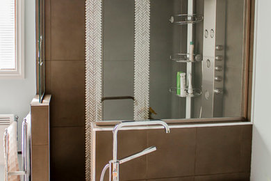 Foto de cuarto de baño principal tradicional renovado de tamaño medio con armarios con paneles lisos, baldosas y/o azulejos beige, paredes grises, suelo de baldosas de porcelana y lavabo bajoencimera