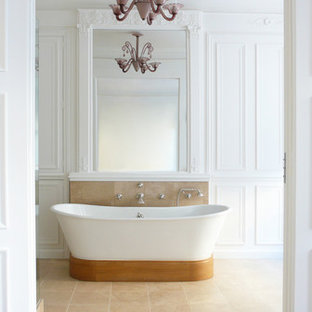Aménagement d'une grand salle de bain principale classique avec une baignoire indépendante, un mur blanc et un sol en travertin.