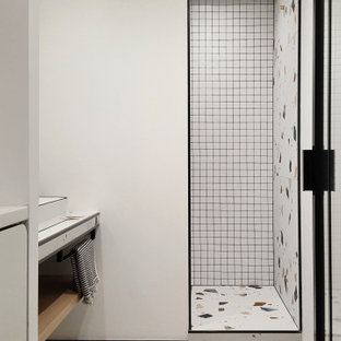 Exempel på ett mellanstort eklektiskt badrum med dusch, med vita skåp, en dusch i en alkov, vit kakel, vita väggar, klinkergolv i keramik, ett avlångt handfat, bänkskiva i glas, flerfärgat golv och med dusch som är öppen