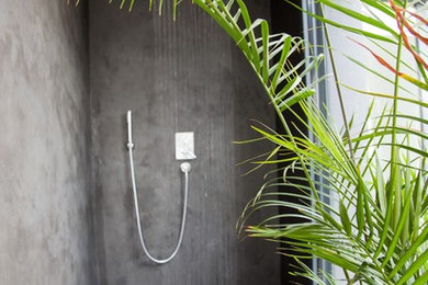 Réalisation d'une salle de bain minimaliste avec une douche à l'italienne, un mur gris et sol en béton ciré.