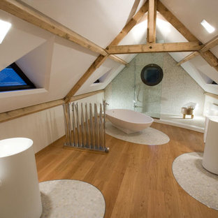 Inspiration pour une grand salle de bain principale design avec un sol en galet, une baignoire indépendante, une douche ouverte, un mur blanc et aucune cabine.