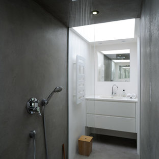 Ispirazione per una stanza da bagno con doccia scandinava con ante lisce, ante bianche, doccia a filo pavimento, pareti bianche, pavimento in cemento e lavabo integrato