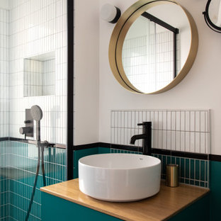 Immagine di una piccola stanza da bagno con doccia moderna con ante lisce, ante blu, doccia a filo pavimento, piastrelle bianche, piastrelle in ceramica, pareti bianche, pavimento in cementine, lavabo a bacinella, top in legno, pavimento blu, porta doccia scorrevole e top beige