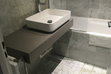 Exemple d'une salle de bain principale tendance de taille moyenne avec une baignoire encastrée, un carrelage gris, du carrelage en marbre, un mur gris, un sol en marbre et un sol gris.