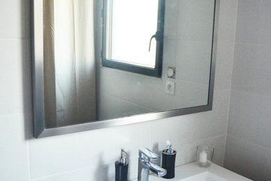 Foto de cuarto de baño minimalista de tamaño medio con baldosas y/o azulejos blancos, paredes blancas, aseo y ducha y lavabo encastrado