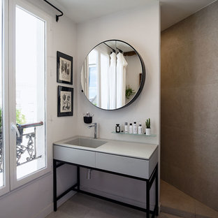 Idées déco pour une salle de bain principale contemporaine de taille moyenne avec un placard à porte plane, des portes de placard grises, un carrelage gris, un mur gris, un lavabo intégré, un sol gris et un plan de toilette gris.