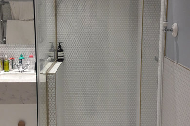 Aménagement d'une salle d'eau rétro avec une douche d'angle et une cabine de douche à porte battante.
