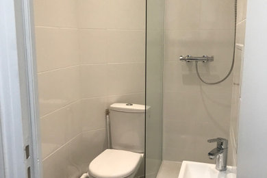 パリにあるお手頃価格の小さなモダンスタイルのおしゃれなバスルーム (浴槽なし) (アルコーブ型シャワー、一体型トイレ	、白いタイル、白い壁、オーバーカウンターシンク、グレーの床、開き戸のシャワー、洗面台1つ) の写真