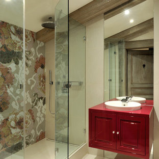 Aménagement d'une salle de bain contemporaine avec un lavabo posé, un placard avec porte à panneau encastré, des portes de placard rouges, un carrelage multicolore, carrelage en mosaïque et un mur beige.