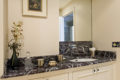 Modelo de cuarto de baño tradicional de tamaño medio con armarios con rebordes decorativos, puertas de armario beige, paredes beige, aseo y ducha, encimera de mármol y encimeras grises