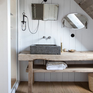 Inspiration pour une salle de bain rustique avec un placard sans porte, des portes de placard en bois clair, un mur blanc, un sol en bois clair, une vasque et un plan de toilette en bois.