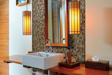 Foto på ett funkis badrum, med ett väggmonterat handfat och träbänkskiva