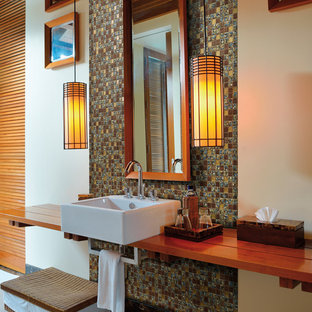 Réalisation d'une salle de bain design avec un lavabo suspendu et un plan de toilette en bois.