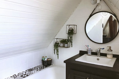 Idée de décoration pour une petite salle d'eau vintage avec des portes de placard beiges, une baignoire encastrée, un carrelage blanc, des carreaux de céramique, un mur blanc, un sol en vinyl, un lavabo encastré, un plan de toilette en stratifié, un sol beige et un plan de toilette noir.
