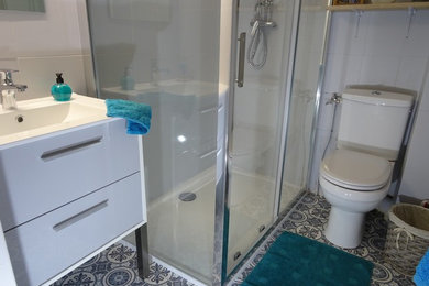 Cette image montre une petite salle d'eau design avec une douche à l'italienne, WC à poser, un carrelage gris, des carreaux de céramique, un mur gris, un sol en linoléum, un plan vasque, un sol gris et une cabine de douche à porte coulissante.