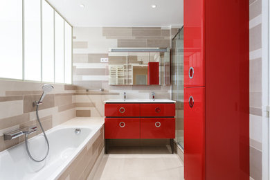 Idée de décoration pour une douche en alcôve design avec des portes de placard rouges, une baignoire posée, un sol beige, une cabine de douche à porte coulissante, un plan de toilette blanc et un placard à porte plane.