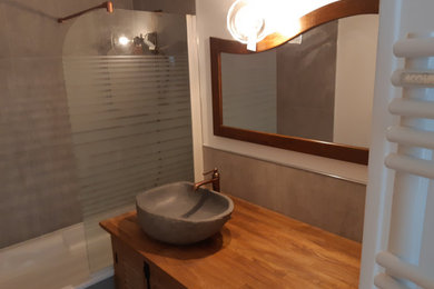 Idée de décoration pour une salle de bain principale design de taille moyenne avec une baignoire posée, un carrelage gris, un carrelage de pierre, un mur blanc, sol en béton ciré, un lavabo posé, un plan de toilette en bois, un sol gris et un plan de toilette marron.