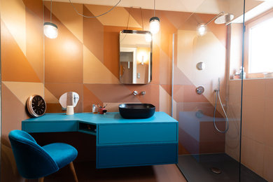 Photo of a medium sized midcentury ensuite bathroom in Strasbourg with beaded cabinets, blue cabinets, a built-in shower, orange tiles, cement tiles, orange walls, cement flooring, a vessel sink, laminate worktops, orange floors, an open shower, blue worktops, a two-piece toilet, a wall niche, a single sink, a floating vanity unit, a wallpapered ceiling, brick walls and a freestanding bath.