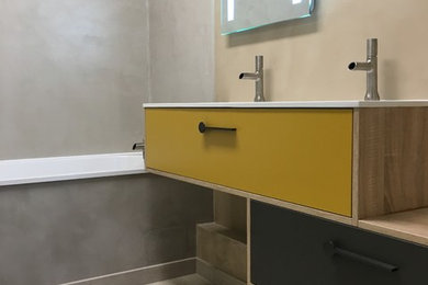 Cette image montre une salle de bain minimaliste avec un placard à porte affleurante, des portes de placard jaunes, une douche à l'italienne, un mur beige, parquet clair, un lavabo intégré, un plan de toilette en surface solide, un sol marron et aucune cabine.